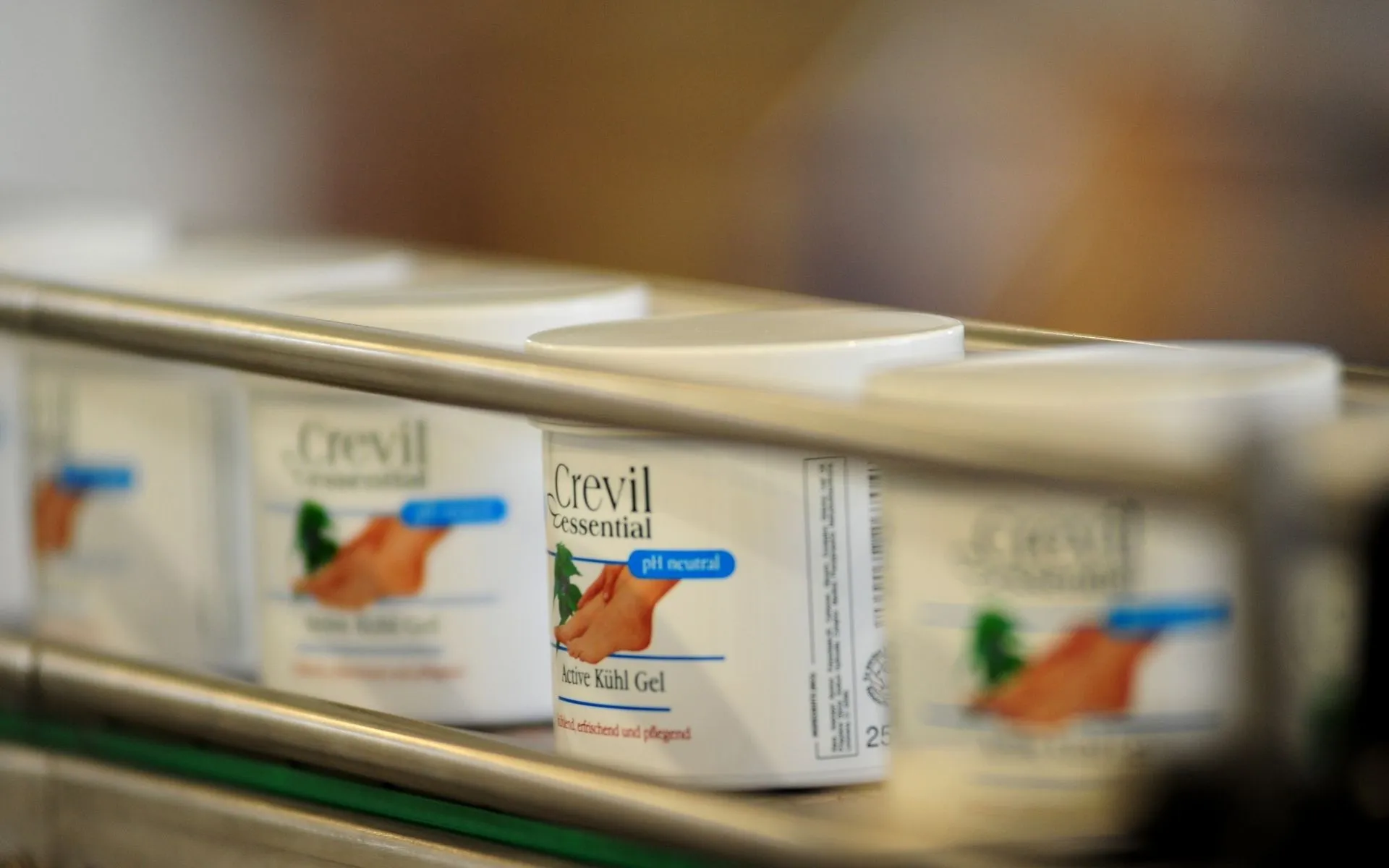 輸送帶上排列著待包裝的 Crevil Essential 乳霜圓罐
